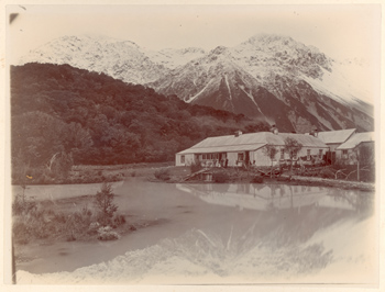 Alpi meridionali della Nuova Zelanda: Borsalino, Zurbrigghen e altri davanti ad  un edificio in lamiera sulle sponde di uno specchio d'acqua