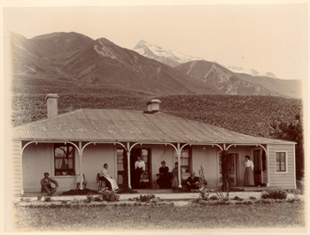 Alpi meridionali della Nuova Zelanda: Borsalino con un groppo di donne sulla veranda di un edificio con tetto in lamiera